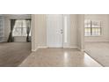 Bright foyer featuring neutral walls, a white front door with sidelight, and easy access to the living spaces at 1227 Juniper Hammock St, Winter Garden, FL 34787