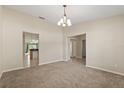 Cozy living room with neutral walls, neutral carpet, and views of the kitchen and hallways at 1227 Juniper Hammock St, Winter Garden, FL 34787