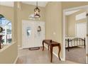 Inviting foyer with double doors, tile flooring, a decorative light fixture, and a glimpse into the adjacent bedroom at 14036 Cherry Bush Ct, Orlando, FL 32828