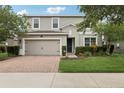 Charming two-story home with a brick driveway, manicured lawn and beautiful landscaping at 1450 Chelsea Manor Cir, Deland, FL 32724
