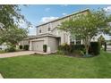 Charming two-story home with a brick driveway, manicured lawn and side yard at 1450 Chelsea Manor Cir, Deland, FL 32724