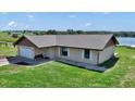 Cozy single-Gathering home with a manicured lawn, gravel landscaping, and a convenient attached garage at 16386 Se 156Th Place Rd, Weirsdale, FL 32195