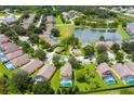 Stunning aerial view of a neighborhood, showing the homes, lake, green spaces, and landscaping at 17614 Woodcrest Way, Clermont, FL 34714