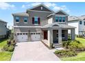 Lovely home featuring a three-car garage, front porch, beautiful pavers, and manicured landscaping at 18309 Oliver Twist Way, Winter Garden, FL 34787