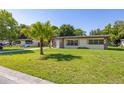 Quaint single-story home with a well-manicured front lawn and mature trees at 2222 Catherine St, Kissimmee, FL 34741