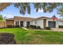 Inviting single-story home boasts lush green lawn, mature trees, and a convenient attached two-car garage at 2344 Whispering Maple Dr., Orlando, FL 32837