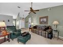 Relaxing living area features a comfortable sofa and chair, ceiling fan, and neutral carpeting at 2344 Whispering Maple Dr., Orlando, FL 32837