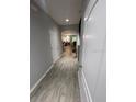 Inviting hallway with wood-look tile leading to a well-lit living space at 2937 Econ Landing Blvd, Orlando, FL 32825