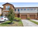 Two-story townhome featuring a landscaped yard, attached two-car garage, and private front entrance at 3331 Windsor Lake Cir, Sanford, FL 32773