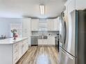 Bright, modern kitchen with stainless steel appliances, island, and white cabinetry at 348 Sigmund Loop, Davenport, FL 33837