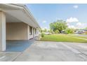 Wide view of the home's front, showcasing the extended covered parking, green lawn, and neighborhood street at 4267 Kirkland Blvd, Orlando, FL 32811