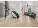 Spacious living room with tile flooring, ceiling fan and stairs to the second floor at 437 Bridgewater Court, Kissimmee, FL 34758