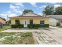 Charming single-story home with a yellow exterior, well-maintained lawn, and inviting entrance at 450 S Buena Vista Ave, Orlando, FL 32835