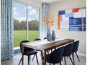 Contemporary dining room featuring stylish furnishings, neutral color palette, and a sliding glass door at 4543 Windy Oak Way, St Cloud, FL 34772