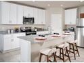 Modern kitchen features white cabinets, granite countertops, stainless steel appliances, and breakfast bar at 4543 Windy Oak Way, St Cloud, FL 34772