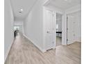 Long hallway with wood look flooring leading to the bathroom, bedroom, and living spaces at 4990 Four Strand Ct, St Cloud, FL 34769