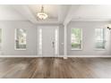 Bright and open foyer featuring wood-look floors, high ceiling, and white columns and trim at 5032 Beach River Rd, Windermere, FL 34786
