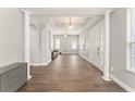 Bright and airy foyer featuring a high ceiling, white columns and trim, and wood-look flooring at 5032 Beach River Rd, Windermere, FL 34786