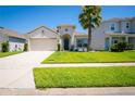 Charming home with a spacious two-car garage, lush lawn, and a beautifully landscaped yard at 5306 Rochester Pl, St Cloud, FL 34771