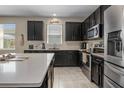 Modern kitchen with stainless steel appliances, dark cabinets, and a large island at 5306 Rochester Pl, St Cloud, FL 34771