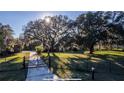 The property features a secure gated entrance, lush landscaping, and mature trees at 6917 Roman Ct, Clermont, FL 34714