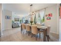 Elegant dining room with a long wooden table, seating for eight, and views of the living room at 8067 Crushed Pepper Ave, Orlando, FL 32817