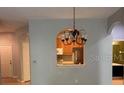 Open-concept dining area with chandelier and archway to the kitchen at 8775 Sartori St # 307, Orlando, FL 32829