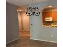Open-concept dining area with chandelier and archway to the kitchen at 8775 Sartori St # 307, Orlando, FL 32829