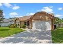 Charming single-story home featuring a well-manicured lawn, inviting front entrance, and two car garage at 10143 Pink Carnation Ct, Orlando, FL 32825
