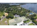 Aerial view of a luxurious home nestled among lush trees with a sparkling lake nearby, offering privacy and scenic beauty at 11923 Lake Butler Blvd, Windermere, FL 34786