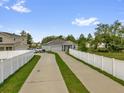 Exterior view showcasing the home's long driveway, solar panels, fenced yard and nearby houses at 123 Zinnia W Ln, Poinciana, FL 34759
