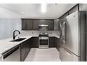 Modern kitchen with stainless steel appliances, granite countertops, and dark cabinets at 13169 Odyssey Lake Way, Orlando, FL 32826