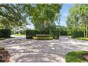 Circular driveway featuring a brick paver design and lush landscaping providing privacy at 1361 Palmer Ave., Winter Park, FL 32789