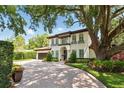 Two-story home featuring a terracotta roof, arched windows with flower boxes and mature shade trees at 1361 Palmer Ave., Winter Park, FL 32789