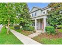 Charming two-story home featuring lush landscaping, inviting porch and red front door at 14208 Shocklach Dr, Winter Garden, FL 34787