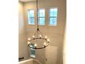 Bright foyer featuring a grand, wrought iron chandelier and abundant natural light from transom windows at 14208 Shocklach Dr, Winter Garden, FL 34787