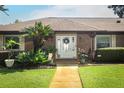 Inviting front entrance of a brick home with decorative plants and a glass front door with sidelights at 1529 Ensenada Dr, Orlando, FL 32825