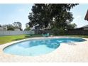 Beautiful backyard pool surrounded by brick pavers and lush landscaping, perfect for relaxation and entertainment at 1529 Ensenada Dr, Orlando, FL 32825
