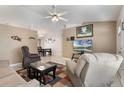 Inviting living room with neutral tones, tile flooring, ceiling fan, and large windows providing ample natural light at 160 Chestnut Ave, Orange City, FL 32763