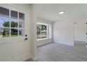 Bright entryway with gray wood floors, fresh paint, and a view to the outside through a large window at 1633 Pinehurst Dr, Casselberry, FL 32707