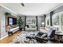 Bright living room with hardwood floors, large windows, and a modern entertainment center at 2109 Montana St, Orlando, FL 32803