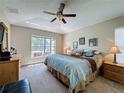 A sun-filled bedroom featuring a plush king-size bed, ceiling fan and an outside view to the pool at 2641 Hemingway Ave, Haines City, FL 33844