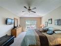 A sunny main bedroom with a king bed and an outside view to the pool at 2641 Hemingway Ave, Haines City, FL 33844