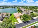 Aerial view of a beautiful home with lush landscaping and a serene lake in the background at 2710 Gorst Rd, Winter Garden, FL 34787