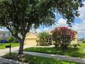Inviting single-story home with a well-manicured lawn and vibrant flowering shrubs in a tranquil setting at 2710 Gorst Rd, Winter Garden, FL 34787