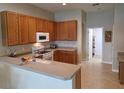Well-lit kitchen featuring wood cabinets, a breakfast bar, and modern appliances at 2710 Gorst Rd, Winter Garden, FL 34787