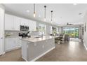Bright, open kitchen featuring stainless steel appliances, granite countertops, and a view to the living room at 284 White Heron Way, St Cloud, FL 34772