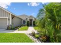 Lovely single-story home featuring a decorative front door and landscaped garden at 2941 Marlberry Ln, Clermont, FL 34714