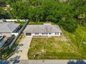 Aerial view of a single-story home, showcasing the property layout, fenced yard, driveway, and surrounding trees at 3104 Lime Tree Dr, Edgewater, FL 32141