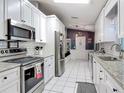 Modern kitchen featuring stainless steel appliances, white cabinets, granite countertops, and tile flooring at 3104 Lime Tree Dr, Edgewater, FL 32141